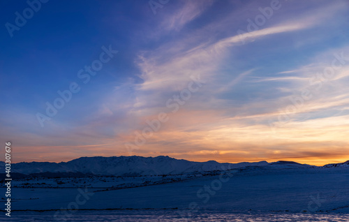 Beautiful panoramic sunset over the mountains and snow-covered hills. Beautiful panoramic sunset over the mountains and snow-covered hills. 