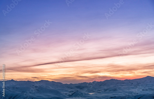Beautiful winter landscape. The mountains peaks snow-covered on the sunset. Dramatic sky. © Inga Av