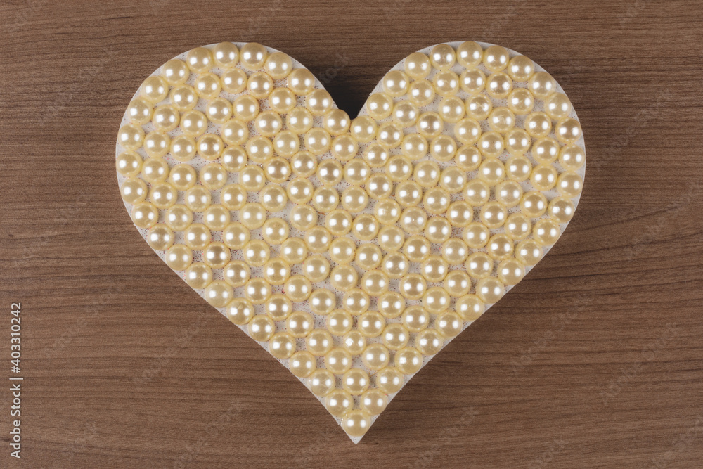 Heart with pearls on wooden background. Heart with pearls on wooden background.