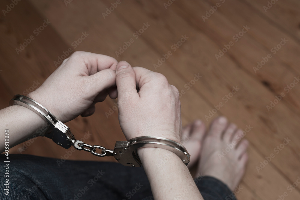 Man detained in handcuffs. Prisoner or arrested man in handcuffs. Male