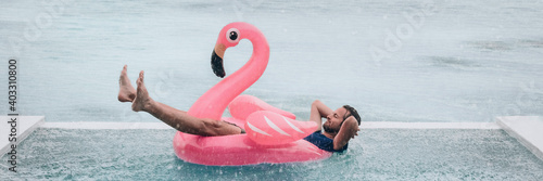 Tela Happy man relaxing in swimming pool flamingo float despite bad rain weather