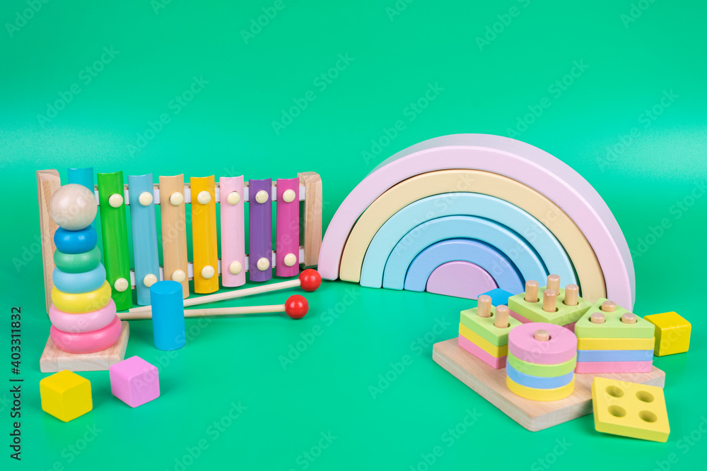 Kids toys collection. Wooden rainbow, educational and music baby toys on  light green background Stock Photo | Adobe Stock