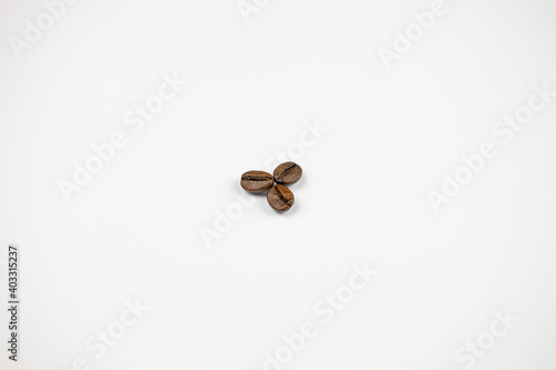 three coffee beans on a white background © Sergiu