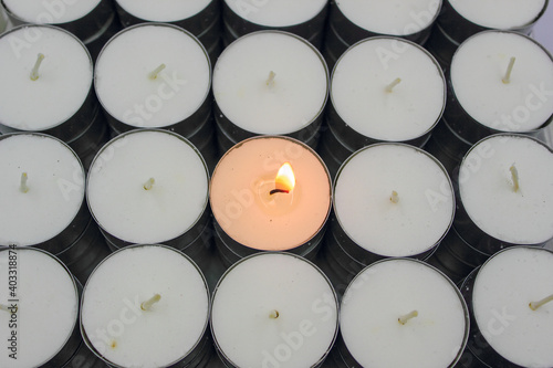 Φωτογραφία white tealight candles with wax, wick and alight with glowing flame isolated on