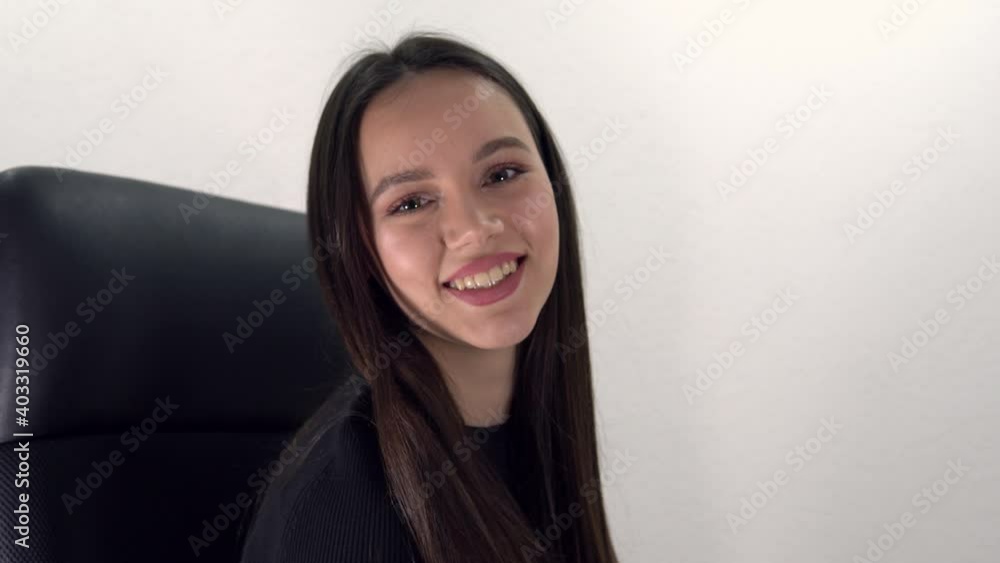 young happy teen turn on business armchair and smile to camera young happy teen turn on business armchair and smile to camera