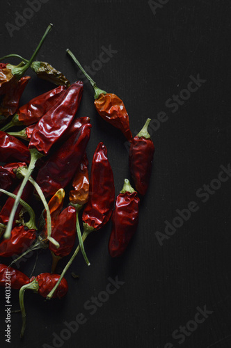 Hot chili pepper on the left on black background