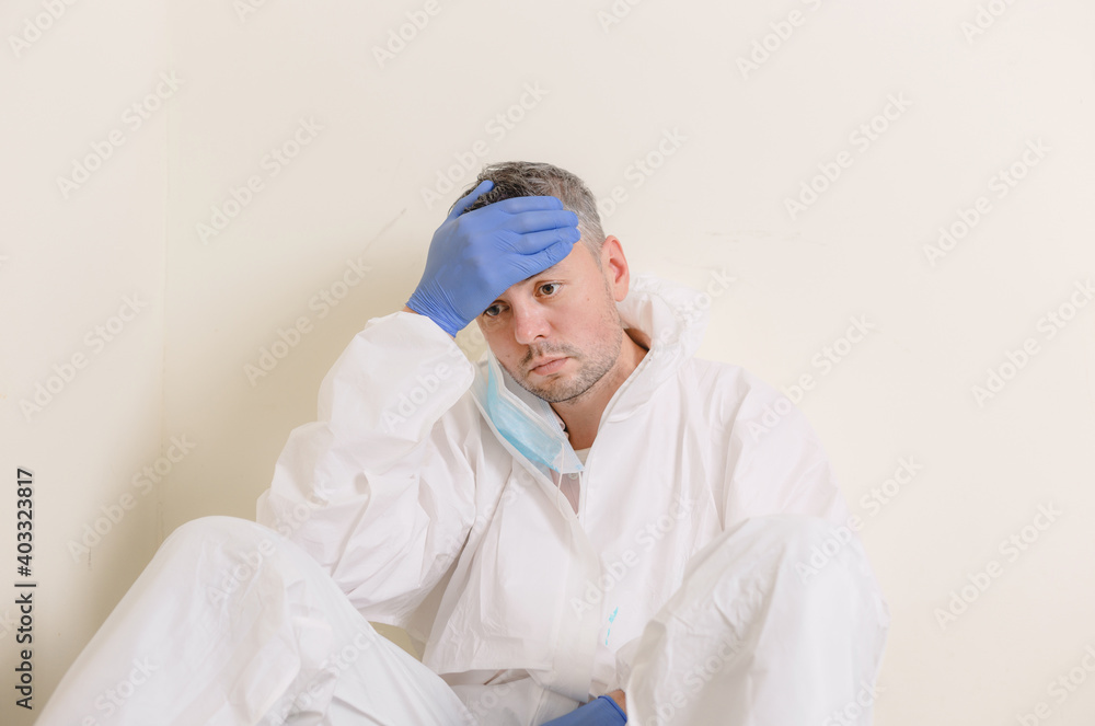 A sad doctor sits on the floor in the corridor of the hospital. Health workers during the Covid19 coronavirus pandemic