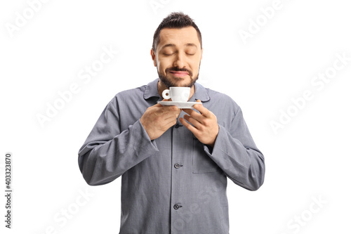Man in pajamas smelling a cup of espresso coffee