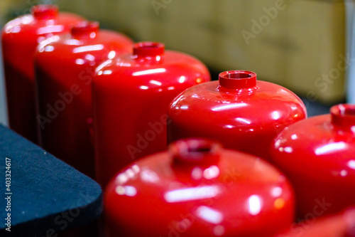 Top view of red empty fire extinguisher tanks in order waiting to be filled, safety first concept, selective focus