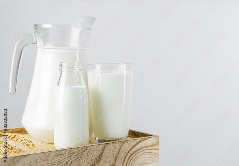 A jug and bottle of fresh milk glass on a wooden crate box. Raw milk is high in calcium and protein to drink for all ages. Milk consumption nutritious and healthy dairy products concept. A jug and bottle of fresh milk glass on a wooden crate box. Raw milk is high in calcium and protein to drink for all ages. Milk consumption nutritious and healthy dairy products concept.