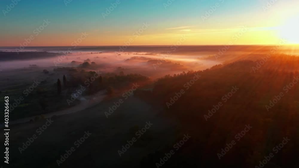 Foggy morning in the countryside at dawn with sun rays from aerial view. Foggy morning in the countryside at dawn with sun rays from aerial view.