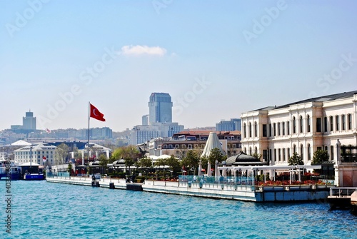 ISTANBUL, TURKEY: Ciragan Palace was once the palace of Ottoman sultans and is now a luxury hotel. Hotel seen from the Bosphorus Strait with a Turkish flag.  © EWY Media