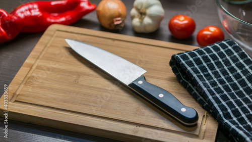 big kitchen Knife on cutting board with vegetables