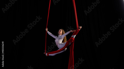 aerial girl professional circus performer performs acrobatic elements twist, flexibility, grace