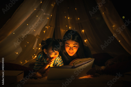 Bild auf Leinwand mom and daughter read bedtime stories fairytale together before going to bed