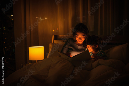 mom and daughter have goodtime reading bedtime stories for daughter