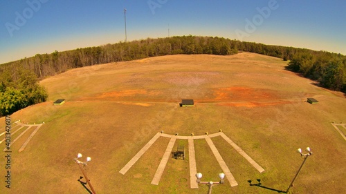 Drone view of trap field, stands, and trap house. 