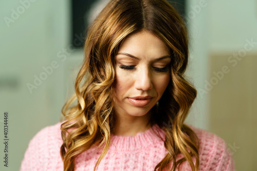 Front view close up portrait of beautiful brunette woman female looking down thinking shy