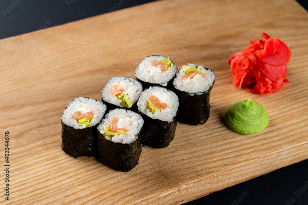 Classic cucumber and lettuce sushi rolls on wooden board, six rolls set on board Classic cucumber and lettuce sushi rolls on wooden board, six rolls set on board