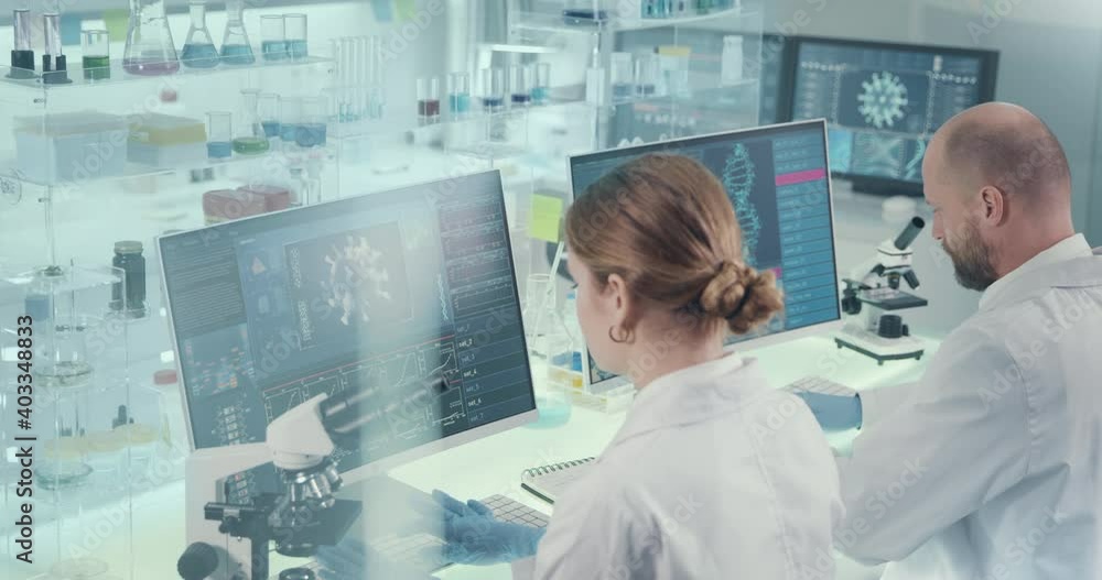 Young microbiologists studying coronavirus. Futuristic lab Young microbiologists studying coronavirus. Futuristic lab