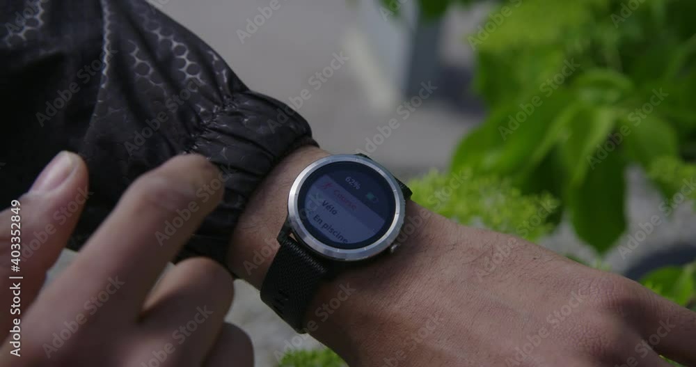 Young black athletic man running in beautiful fields powerful active looks at his watch Young black athletic man running in beautiful fields powerful active looks at his watch