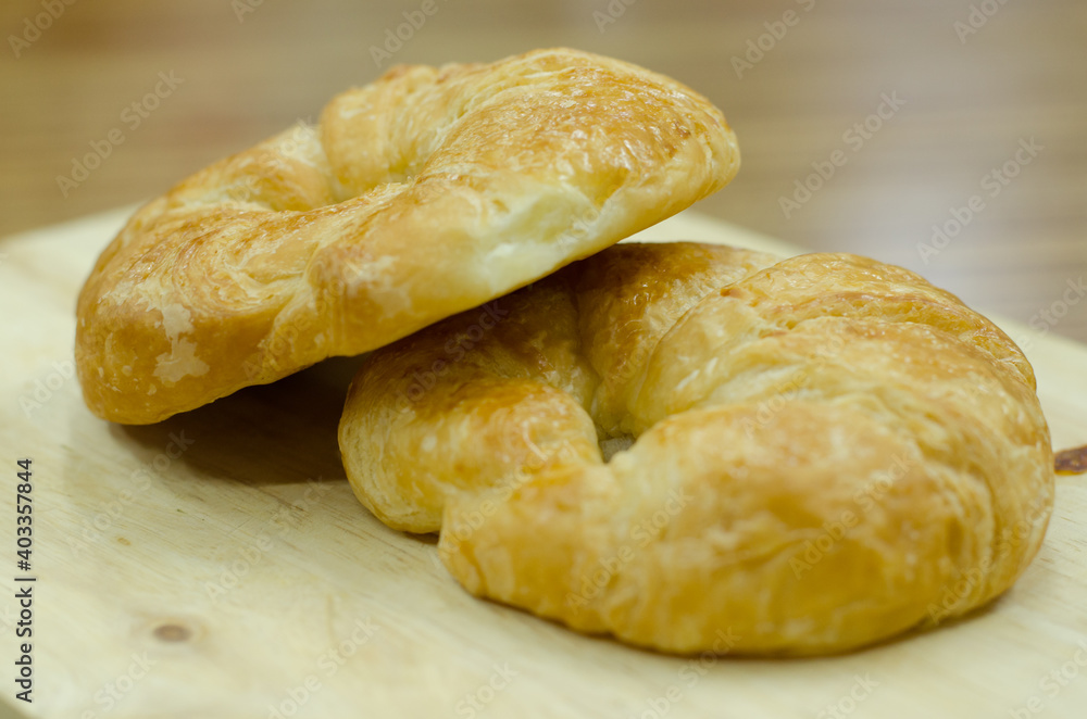 croissants with bite marks on wood and blur