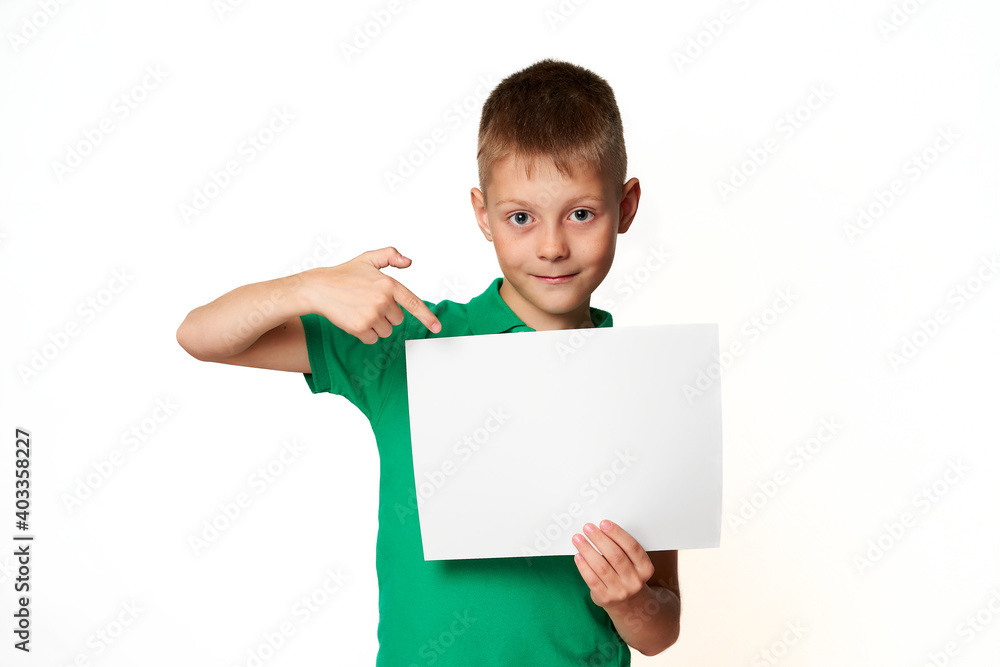 Boy with blank sheet of paper for advertising points his finger Boy with blank sheet of paper for advertising points his finger