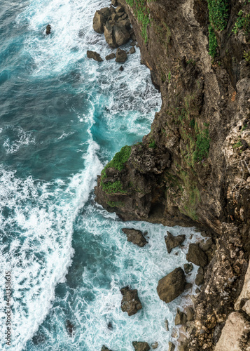 Blue ocean waves splashing on rock landscape on Bali Island - Uluwatu, Indonesia