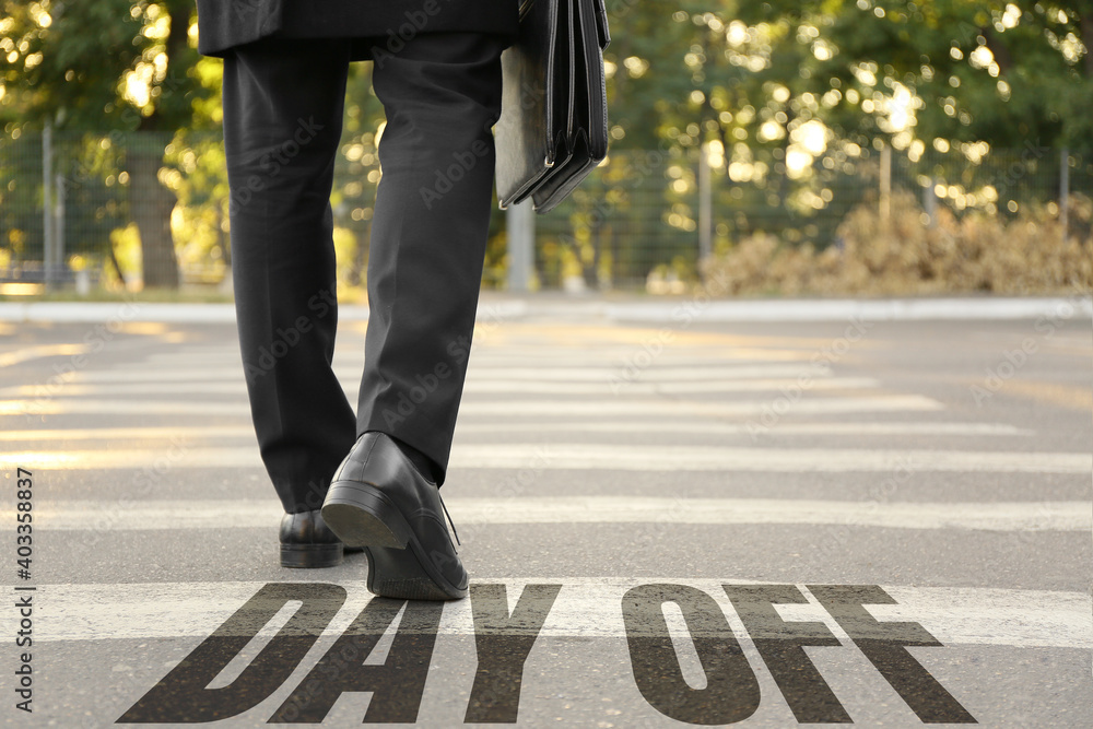Text DAY OFF and young businessman crossing road Text DAY OFF and young businessman crossing road