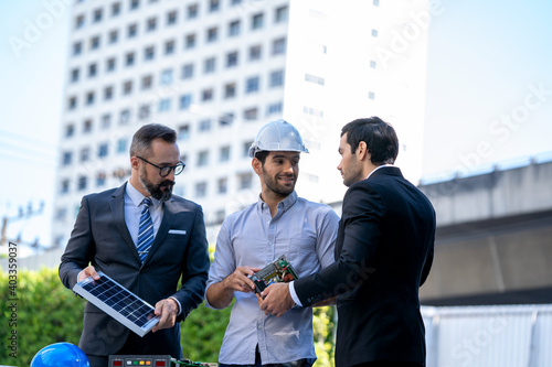 Businessmen and engineers discuss of renewable energy working on an innovative more efficient solar panel battery concept.