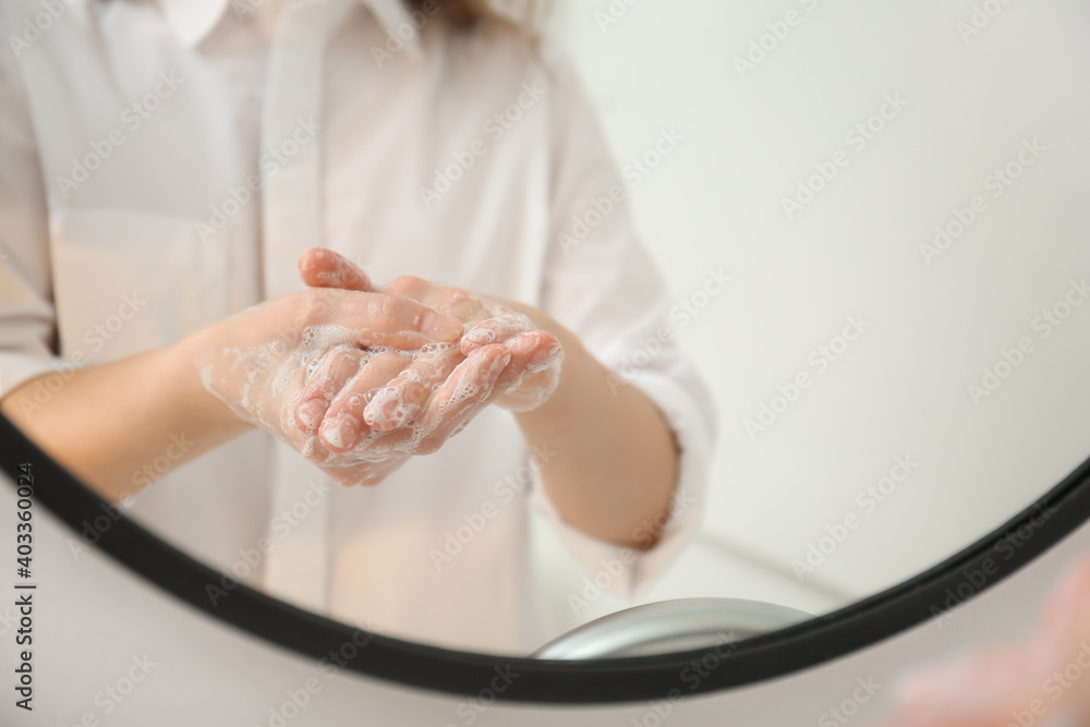 Young woman washing her hands in bathroom Young woman washing her hands in bathroom