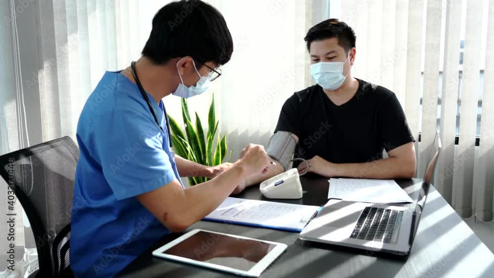 Medical concept a smart male doctor wearing a mask consulting with patient at his modern clinic. Medical concept a smart male doctor wearing a mask consulting with patient at his modern clinic.