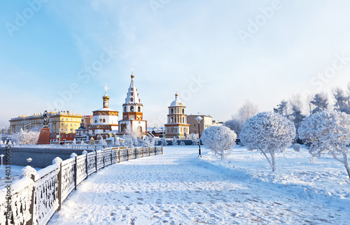 Siberia. Irkutsk. View from the snow-covered lower embankment of the Angara River to the Epiphany Cathedral and the monument to the founders of the city on a cold day. Beautiful winter cityscape photo