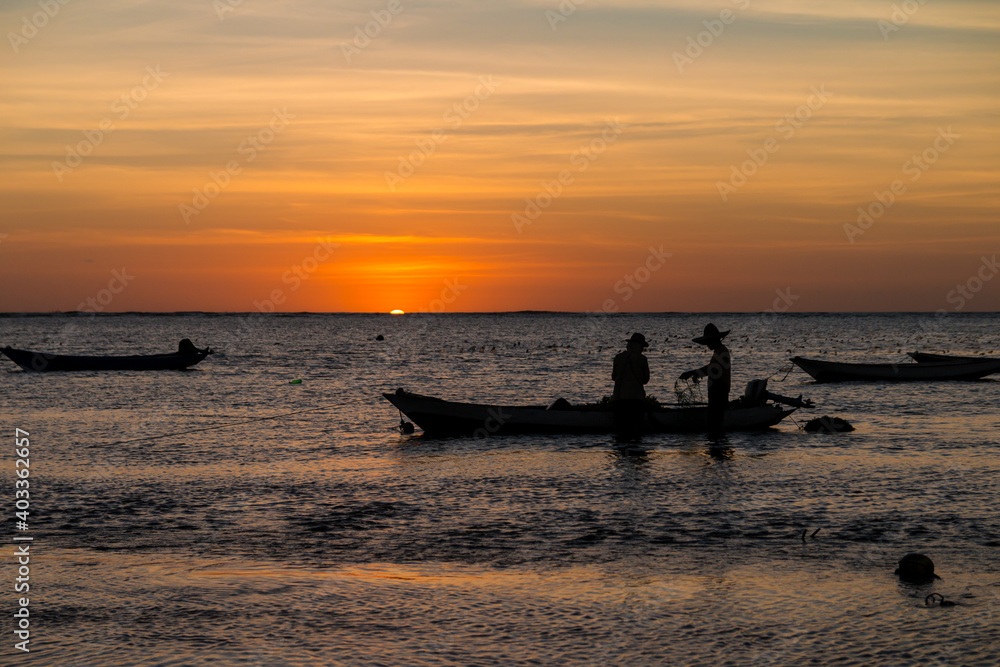 Sumba,Indonesia-September 2020: Fisherman fishing at the boat the water with ship with sunset views