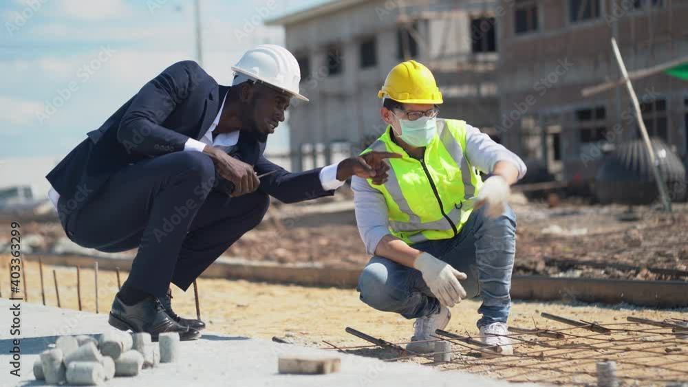 asian foreman and african american architect checking steel structure road outdoors on construction site at village . contractor worker Inspection and correction rebar steel cage . quality control asian foreman and african american architect checking steel structure road outdoors on construction site at village . contractor worker Inspection and correction rebar steel cage . quality control