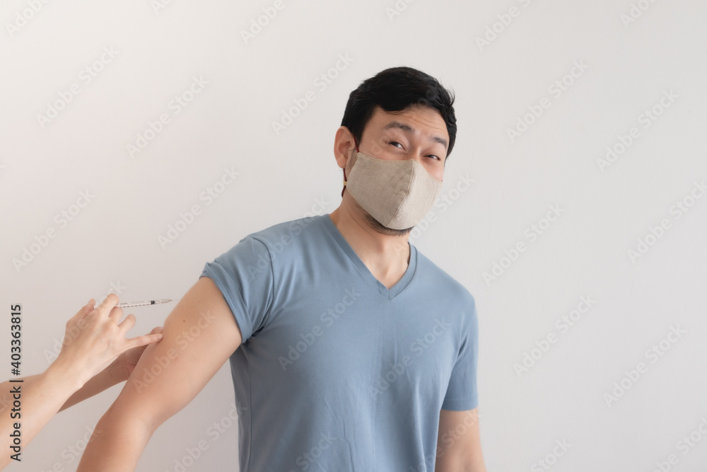 Asian man is being injected a vaccine for virus protection. Concept of Covid-19 vaccination. Asian man is being injected a vaccine for virus protection. Concept of Covid-19 vaccination.