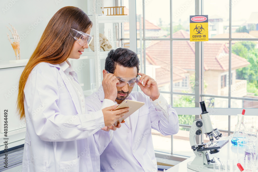 Doctor and microbiologist with vacuum tubes for samples with COVID 19 infection atypical pneumonia virus in laboratory Doctor and microbiologist with vacuum tubes for samples with COVID 19 infection atypical pneumonia virus in laboratory