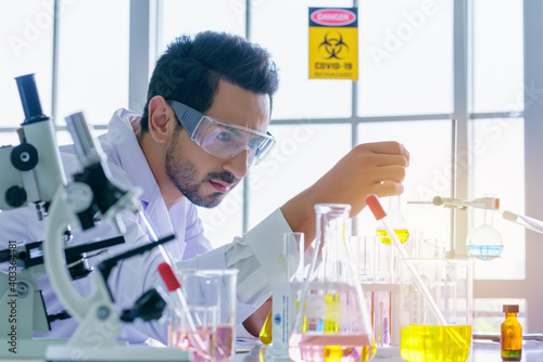 Doctor and microbiologist with vacuum tubes for samples with COVID 19 infection atypical pneumonia virus in laboratory