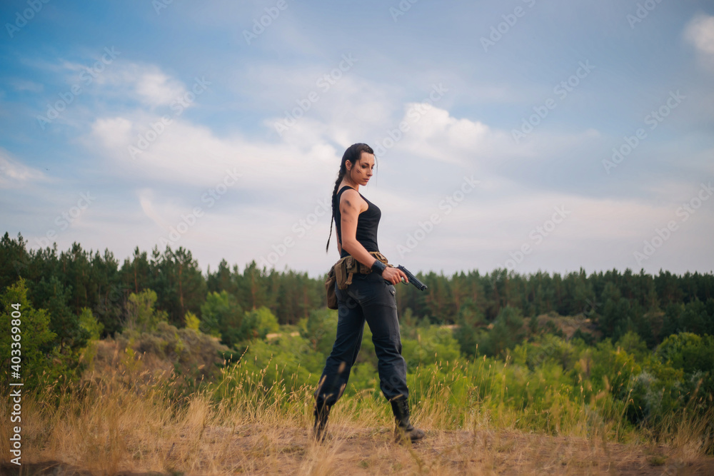 Girl with a pistol in nature. Against the background of yellow grass. The female army on the hunt. Girl with a pistol in nature. Against the background of yellow grass. The female army on the hunt.
