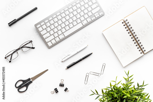 Flat lay office workspace with keyboard and office supplies, top view