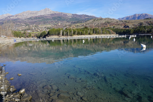 mirror reflection of the mountains in Serre Ponçon lake, France with its clear water