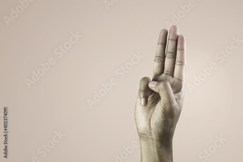 A man hand raised three fingers as a symbol of resistance to dictatorship or scout promise. photo