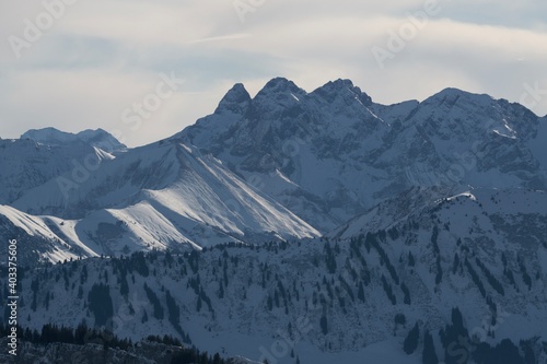 Winterliche Landschaft der schneebedeckten bayerischen Alpen vor blauem Himmel im Sonnelicht