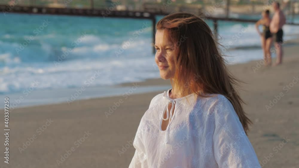A young woman smiles, relaxes and enjoys life on a sandy city or resort beach. A young woman smiles, relaxes and enjoys life on a sandy city or resort beach.