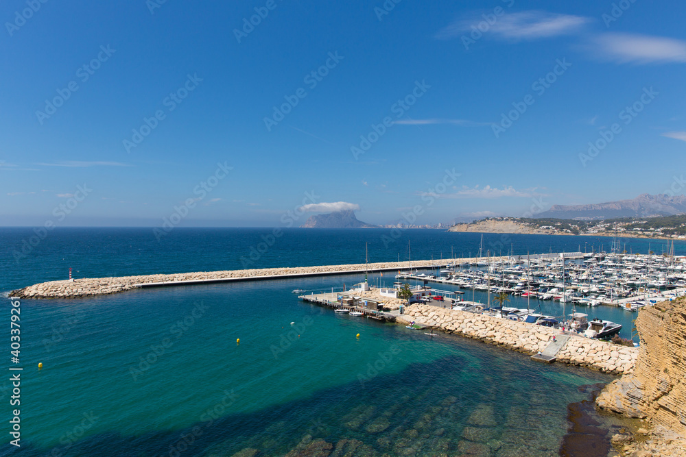 Moraira Spain marina view to Calp rock with boats and clear blue sea