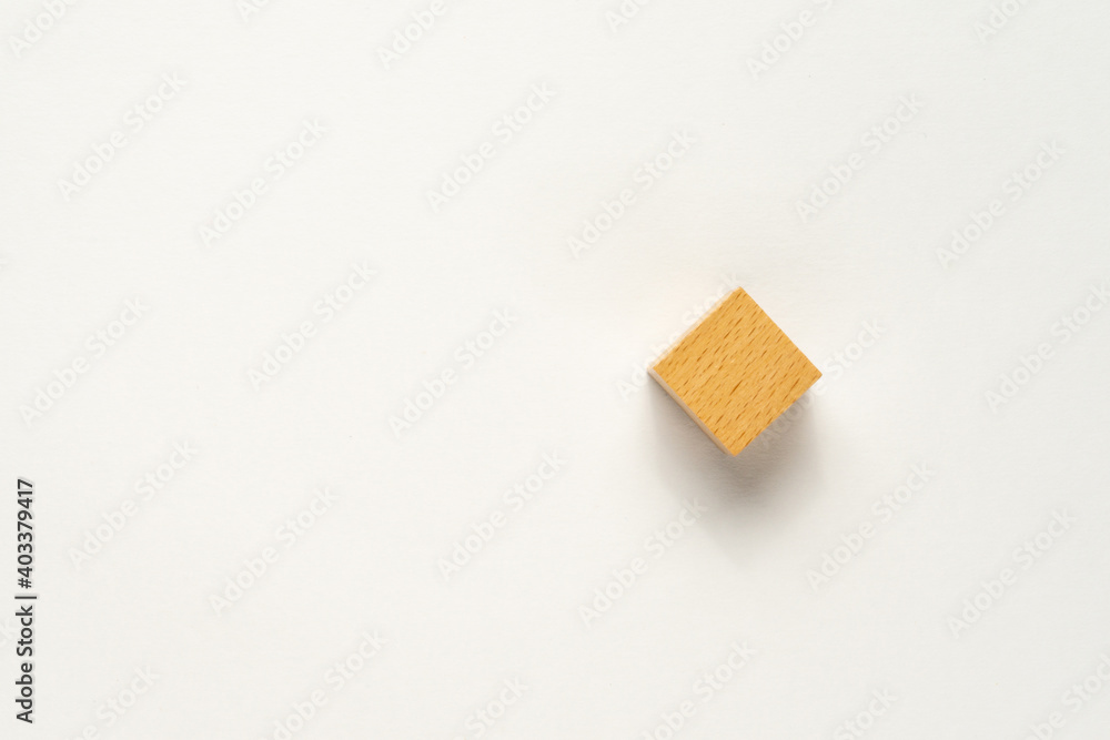 A wooden cube on white background. Flat lay view concept with a copy space. A wooden cube on white background. Flat lay view concept with a copy space.