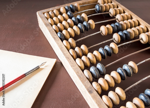 An old wooden abacus  an account book  a fountain pen on the table.