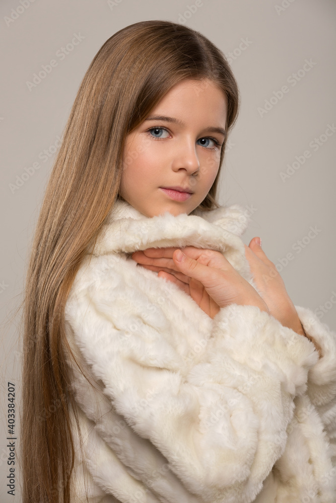 portrait of a beautiful child girl with long beautiful hair styled in a hairstyle and a fur white fur coat portrait of a beautiful child girl with long beautiful hair styled in a hairstyle and a fur white fur coat
