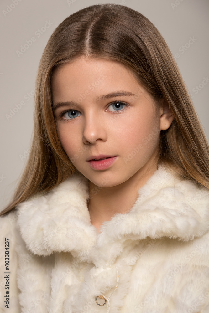 portrait of a beautiful child girl with long beautiful hair styled in a hairstyle and a fur white fur coat portrait of a beautiful child girl with long beautiful hair styled in a hairstyle and a fur white fur coat