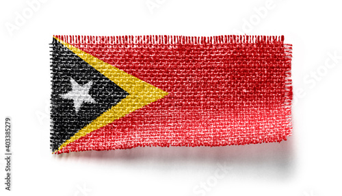 East Timor flag on a piece of cloth on a white background